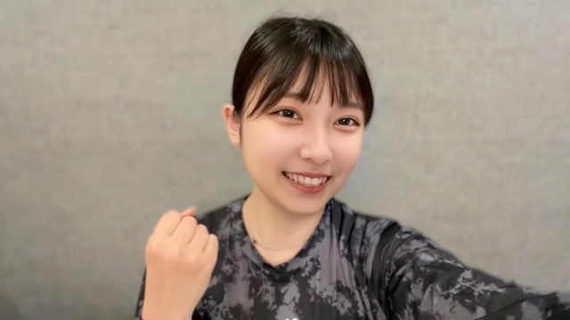 作業着姿でガッツポーズする場面